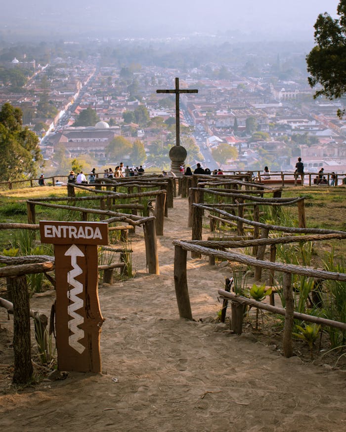 Stunning view from Hill of the Cross overlooking Guatemala City with entrance sign and wooden railings.